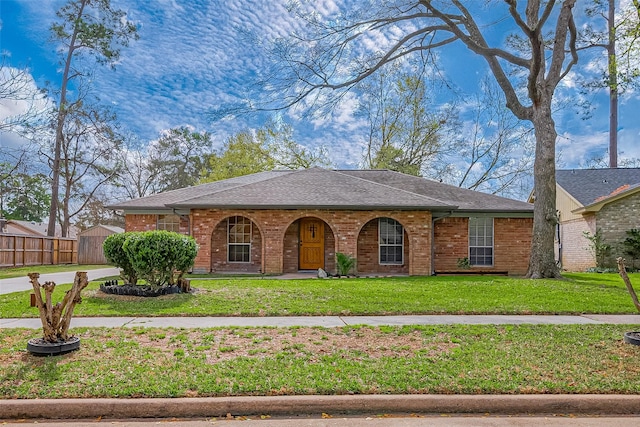 ranch-style home featuring brick siding, covered porch, a front yard, and fence