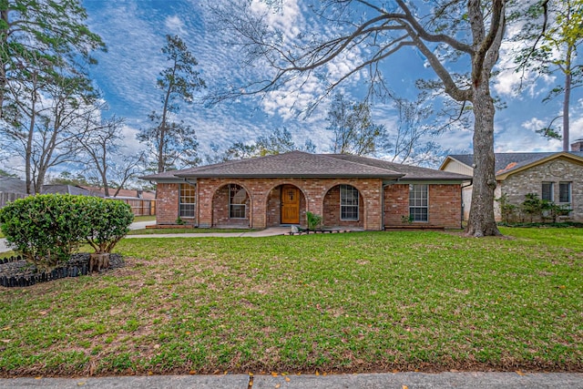 view of front of home featuring brick siding and a front yard