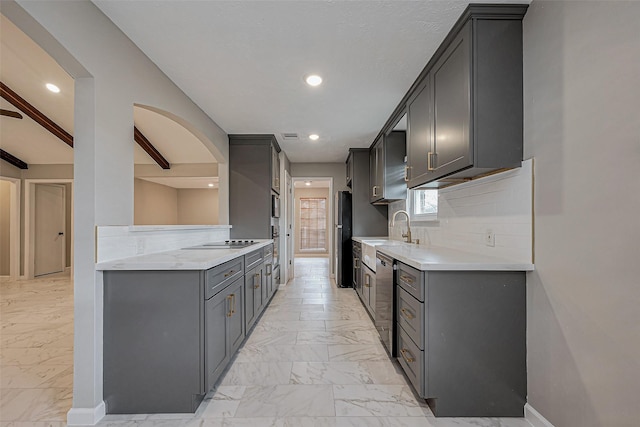 kitchen featuring a sink, decorative backsplash, black appliances, light countertops, and marble finish floor