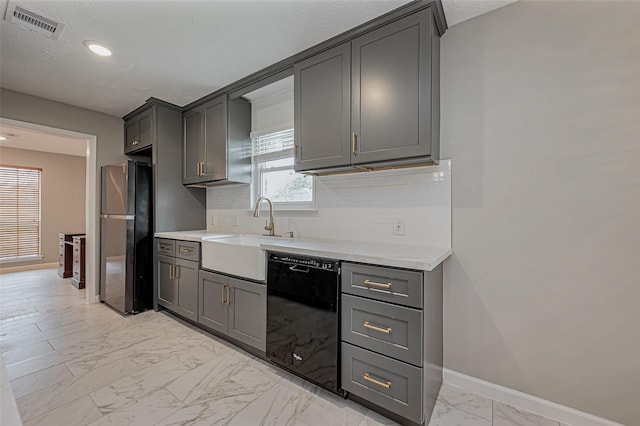 kitchen featuring visible vents, freestanding refrigerator, a sink, black dishwasher, and marble finish floor