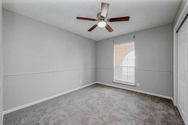 unfurnished bedroom with a ceiling fan, a textured ceiling, a closet, carpet flooring, and baseboards