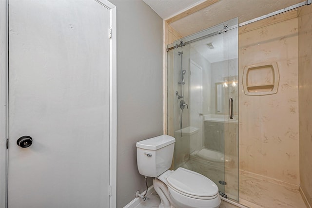 bathroom featuring toilet, baseboards, and a stall shower