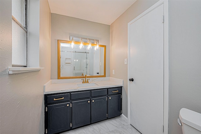 bathroom featuring walk in shower, toilet, marble finish floor, and vanity