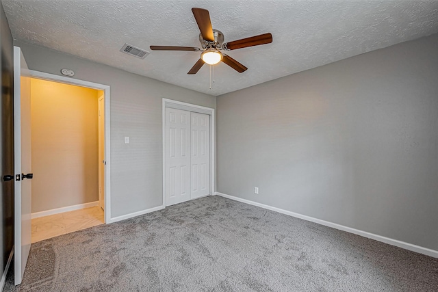 unfurnished bedroom featuring visible vents, baseboards, a closet, and carpet flooring