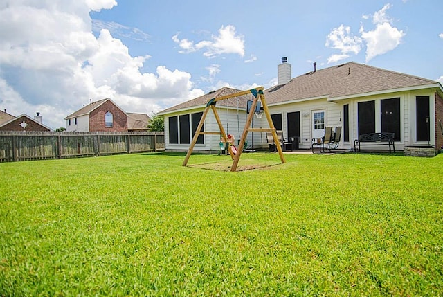 back of property with a fenced backyard, a patio area, a chimney, and a yard