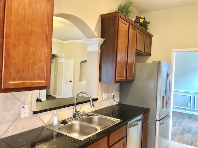 kitchen featuring wood finished floors, a sink, stainless steel dishwasher, tasteful backsplash, and brown cabinets