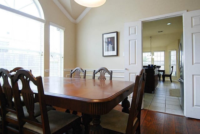 dining room featuring crown molding, lofted ceiling, and dark wood-style flooring