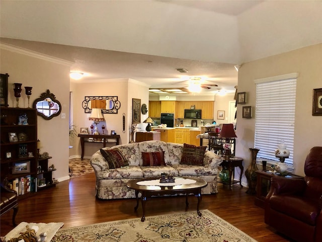 living area featuring dark wood finished floors, ceiling fan, baseboards, and ornamental molding