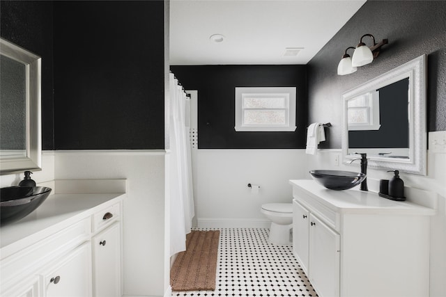 full bathroom with vanity, toilet, visible vents, and baseboards