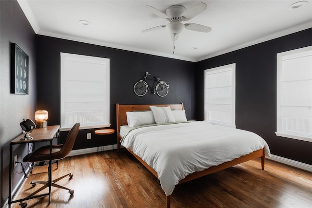 bedroom with ceiling fan, crown molding, baseboards, and wood finished floors