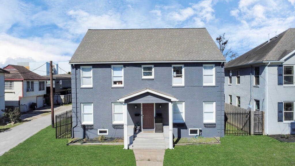 2903 Wichita St, Houston, TX 77004 - view of front of home with a front lawn, fence, brick siding, and a shingled roof