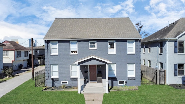 view of front of home with a front lawn, fence, brick siding, and a shingled roof