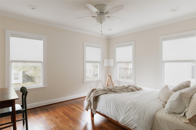 bedroom featuring baseboards, ceiling fan, crown molding, and hardwood / wood-style flooring