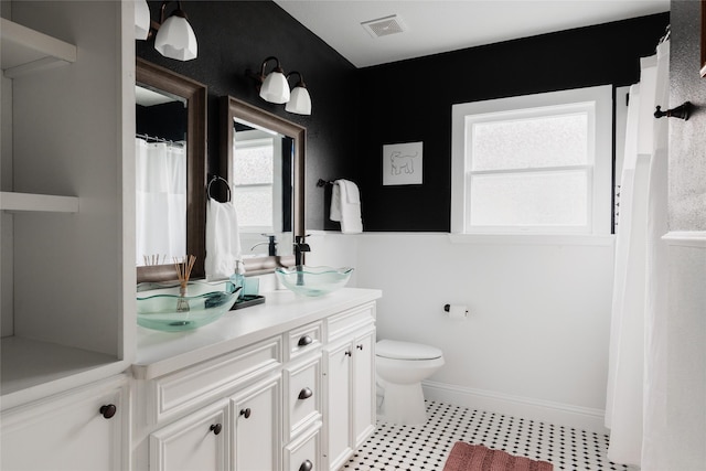 bathroom with visible vents, toilet, vanity, and baseboards