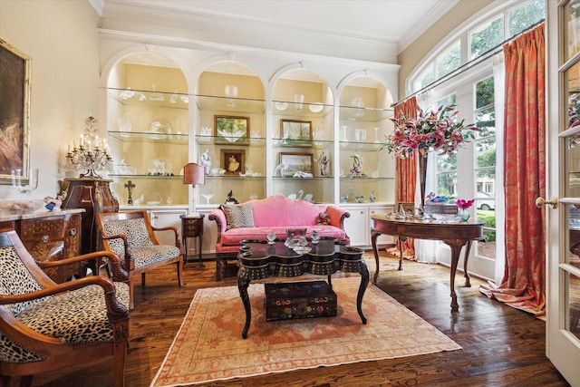 living area featuring wood finished floors and crown molding