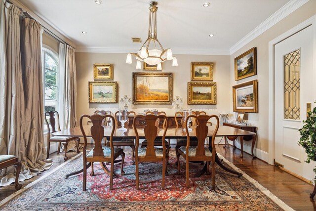 dining room featuring visible vents, crown molding, baseboards, a chandelier, and wood finished floors