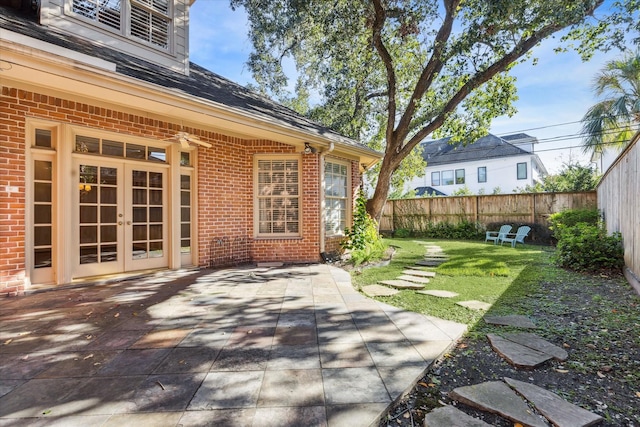 view of yard featuring a patio, french doors, and fence