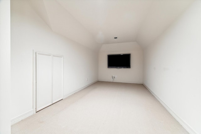 bonus room featuring vaulted ceiling and light carpet