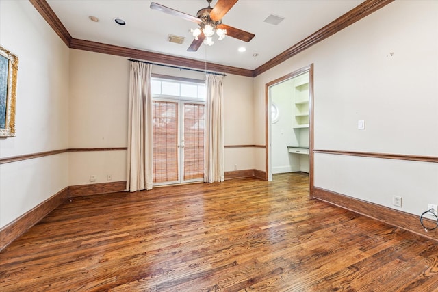 unfurnished room featuring wood finished floors, visible vents, baseboards, ceiling fan, and crown molding