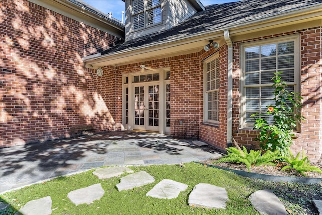 entrance to property featuring french doors, brick siding, and a patio area