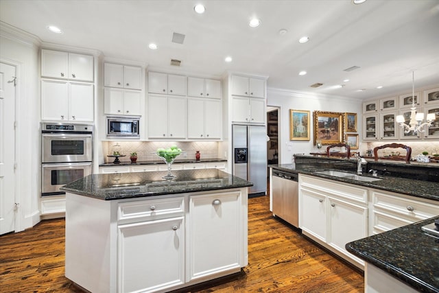 kitchen featuring a sink, a kitchen island, appliances with stainless steel finishes, white cabinets, and dark wood-style flooring