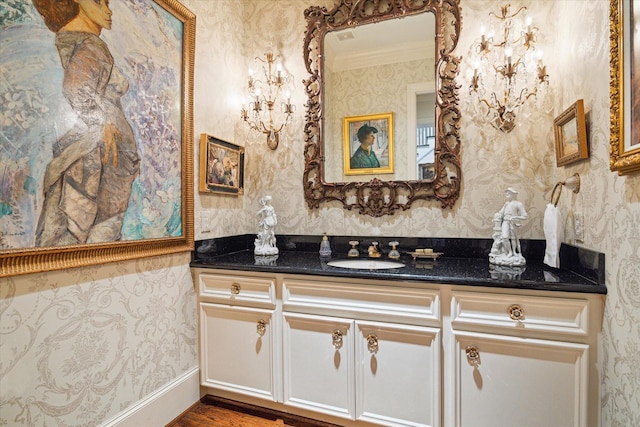 bathroom with wallpapered walls and vanity