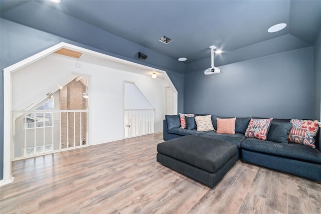 living area featuring arched walkways, visible vents, and wood finished floors