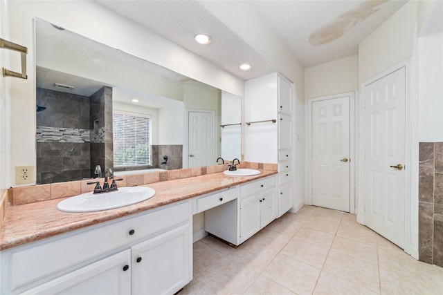 bathroom with double vanity, tile patterned floors, walk in shower, and a sink