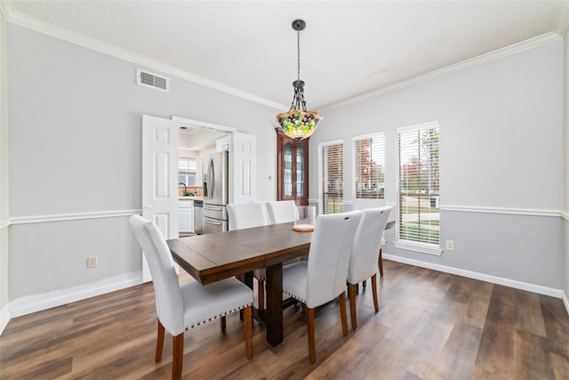 dining room with dark wood finished floors, visible vents, baseboards, and ornamental molding