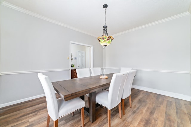 dining room featuring baseboards, wood finished floors, and crown molding