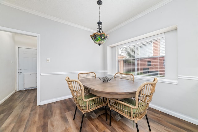 dining area with wood finished floors, baseboards, and ornamental molding