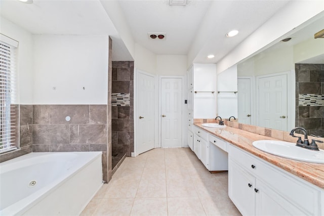 full bathroom with a sink, a tub with jets, tile patterned floors, and double vanity