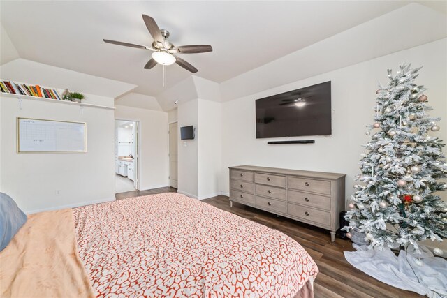 bedroom featuring a ceiling fan, ensuite bath, dark wood-style floors, baseboards, and vaulted ceiling