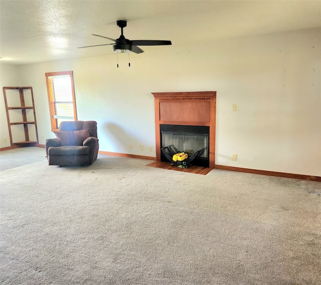 unfurnished room with light carpet, ceiling fan, a tile fireplace, and baseboards