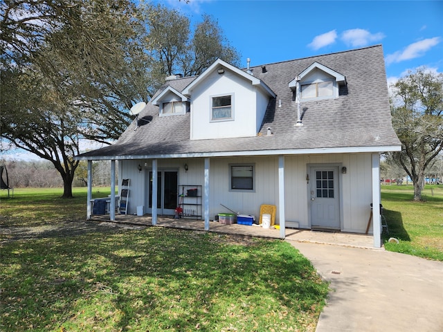 view of front facade featuring a front yard and a shingled roof