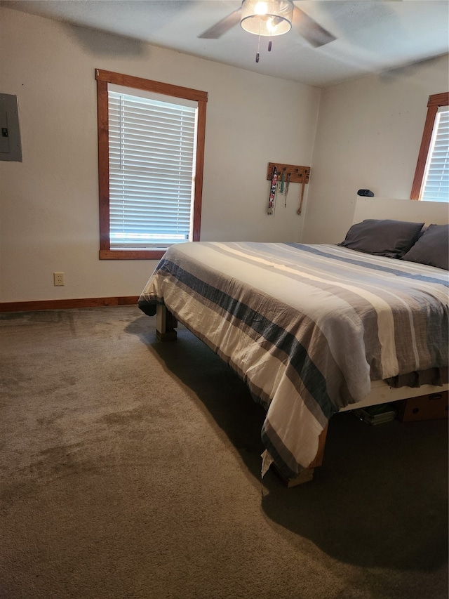 carpeted bedroom featuring electric panel, ceiling fan, and baseboards