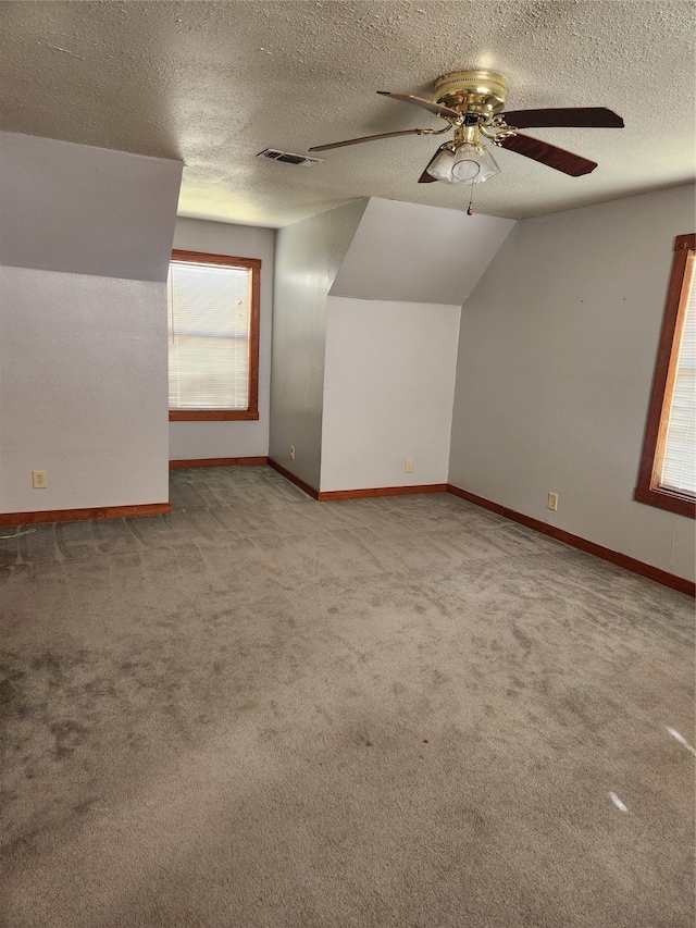 additional living space with baseboards, carpet, visible vents, and ceiling fan