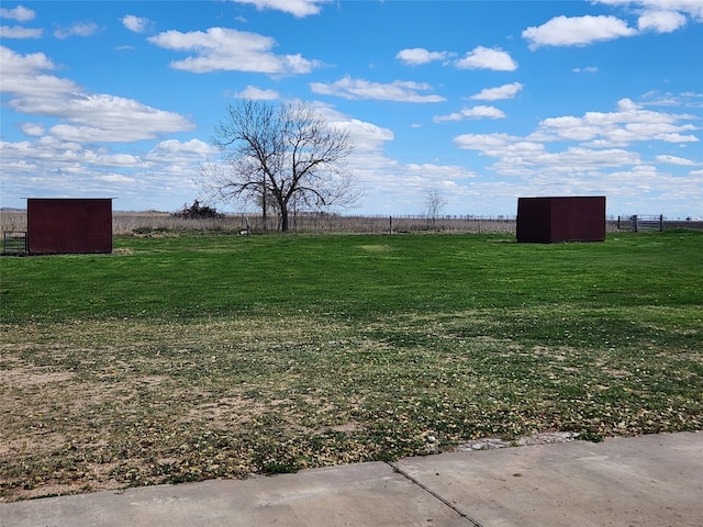 view of yard with an outdoor structure, a storage unit, and a rural view