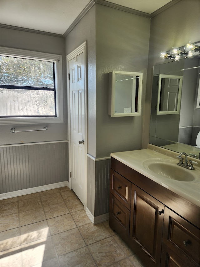 bathroom featuring a wainscoted wall, vanity, and crown molding