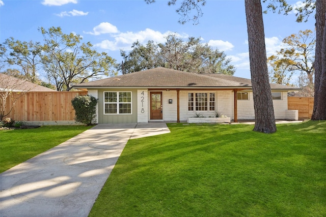 view of front of home with board and batten siding, a front yard, and fence