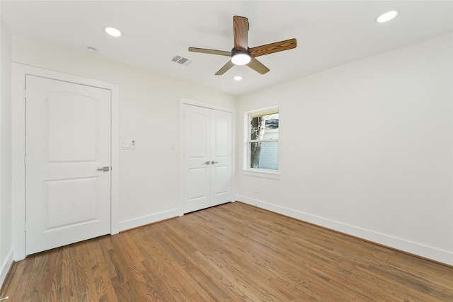 unfurnished bedroom with recessed lighting, wood finished floors, and visible vents