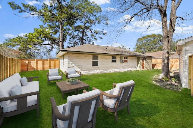 rear view of property with stone siding, a lawn, outdoor lounge area, and a fenced backyard