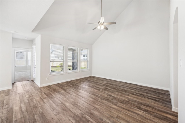 unfurnished living room with ceiling fan, baseboards, dark wood finished floors, arched walkways, and high vaulted ceiling