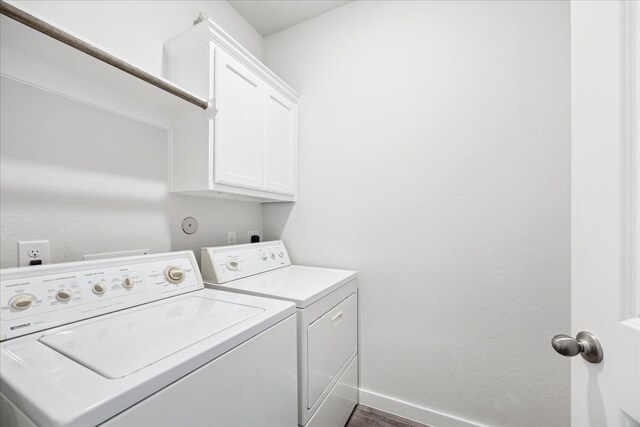 clothes washing area featuring dark wood-style floors, cabinet space, independent washer and dryer, and baseboards