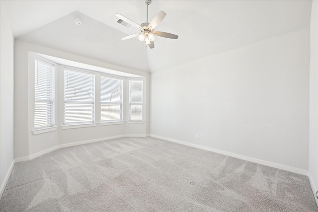 spare room featuring baseboards, light colored carpet, a ceiling fan, and vaulted ceiling