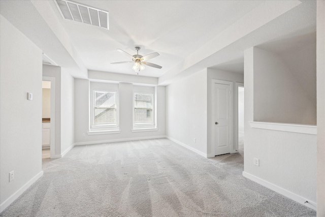 carpeted spare room with baseboards, visible vents, and ceiling fan