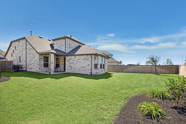 back of house featuring brick siding, central AC unit, a yard, a fenced backyard, and a patio