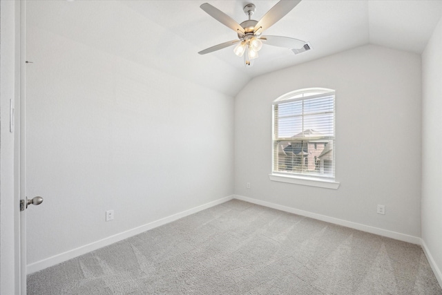 spare room featuring lofted ceiling, light colored carpet, visible vents, and baseboards