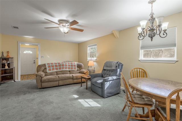 carpeted living room with visible vents and ceiling fan with notable chandelier