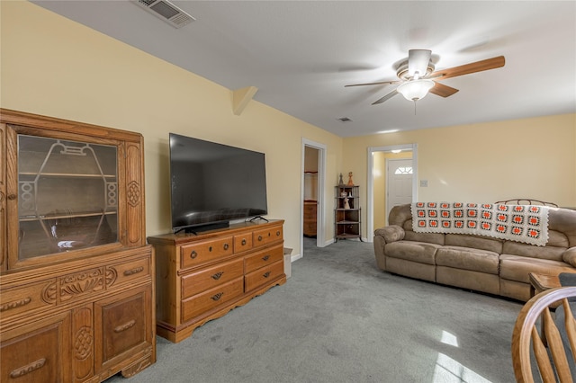 living area featuring visible vents, light colored carpet, and ceiling fan